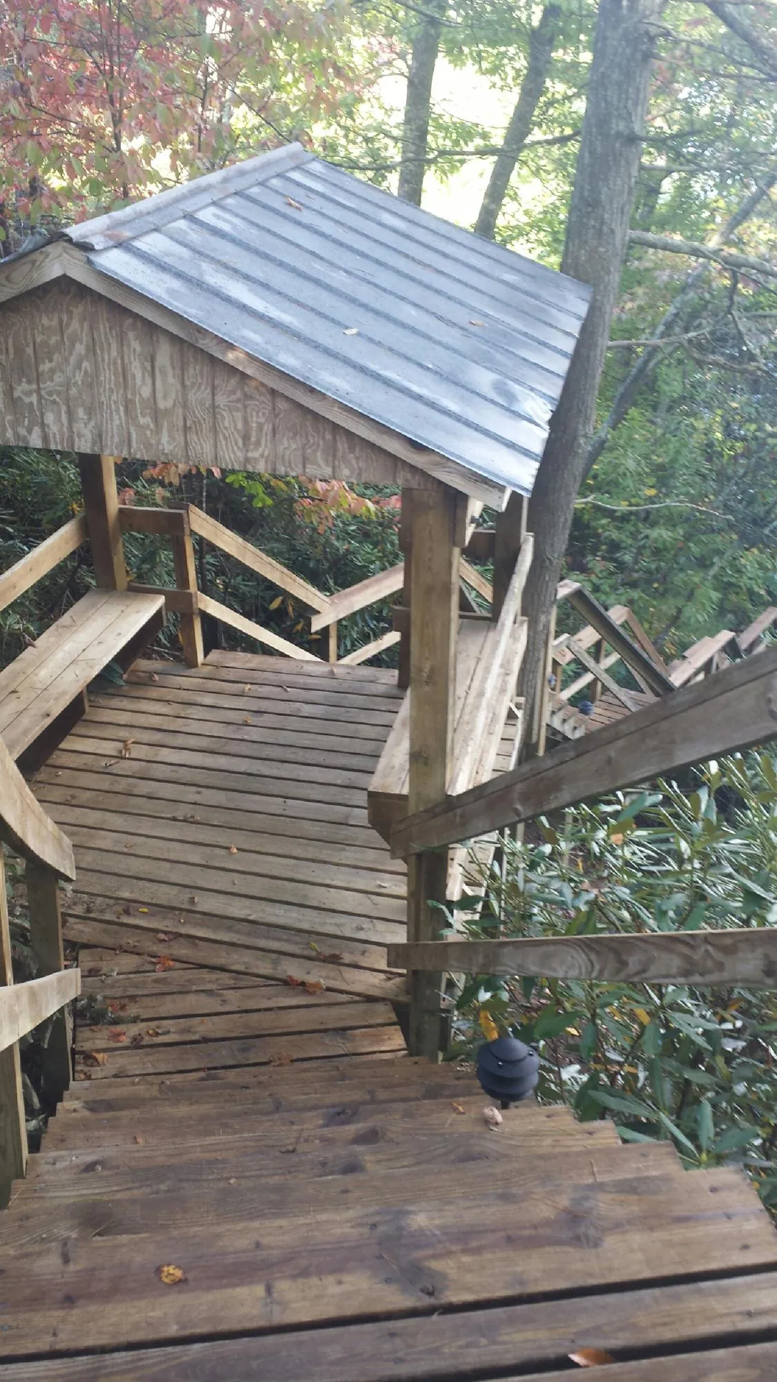 Metal roofed shelter over wooden steps on a wooded walkway — Skylight Repair & Installation work by our crew in Kempton