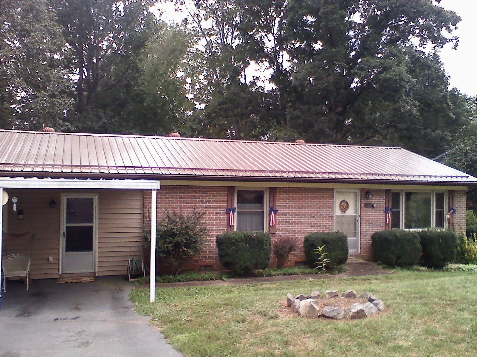 Bronze metal roof and carport on a brick ranch home — Roof Repair work by our crew in Kempton